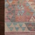 Close-up of rug corner showcasing intricate border pattern and plush texture on dark wooden floor