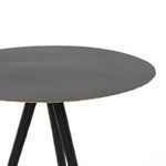 Modern gray living room with leather chairs and patterned rug featuring the Trula black tripod end table