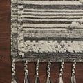 Close-up of the rug corner showing texture variations, fringe detail, and hardwood floor context