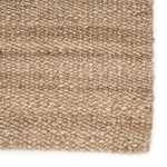 Detailed close-up of the rug’s woven tan fibers and subtle color variation near edge