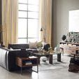 Black leather left sectional shown in modern living room with glass coffee table and rustic wood furniture