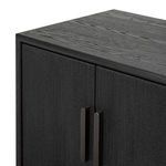 Close-up of cabinet doors with matte black brushed handles and textured vertical grain