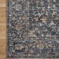 Corner of rug flat on floor highlighting fringe and detailed pattern along edge