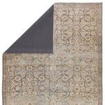 Top corner of rug flipped to reveal dark charcoal backing material