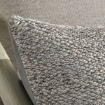 Close-up detail of chunky, recycled woven fiber texture on pillow corner