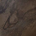 Close-up of uneven, mottled iron finish with dark and light patches
