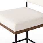 Close-up of Benton Stool seat cushion showing textured white fabric and oak wood edge