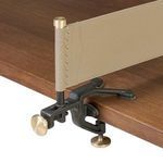 Beige leather sling net attached with black cast iron and brass clamp on table edge