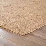 Close-up corner view showing tight geometric weave and the rug’s textured edge on wood floor
