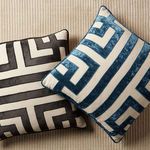 Blue and beige pillow paired with similar pillow in black and beige on textured fabric surface