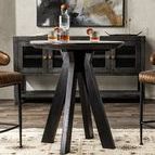 Rodrigo Round Mango Wood Table styled in dining room with chairs, drinks, and art