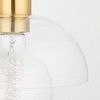 Close-up of clear glass dome and filament bulb inside with smooth gold socket above
