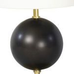 Detailed view of the top part of the spherical black metal body with brass rod supporting the linen shade