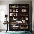 Home office with Ivy Bookcase fully stocked and a wooden desk near window with a black leather office chair