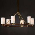 Lit chandelier hanging near dark wall with linen shades glowing softly