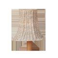 Bell-shaped chandelier shade made of whitewashed woven seagrass with a natural wood fixture