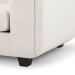 Close-up zoom on sofa leg showing matte black tapered wooden feet