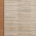Close-up corner of Arden rug on a wooden floor highlighting finishing edge and subtle color stripes