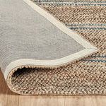 Back side of rug folded over highlighting plain woven backing and edge binding