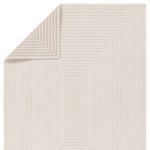 Reversed corner of rug folded to reveal alternating high-low pile geometric pattern on back