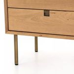 Front view with brighter natural oak finish and polished brass hardware on nightstand