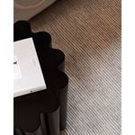 Overhead close-up focusing on scalloped tabletop surface with book on top