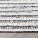 Close-up of textured jute and cotton fibers with ivory and slate blue stripes, showing weave detail