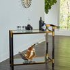 Boulevardier Bar Cart styled with decanter, bottles, and decorative metal leaves in bright modern room