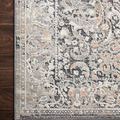 Close-up of rug corner on dark wood floor showing detailed border and subtle color accents