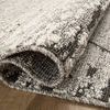 Close-up of folded Fabian Grey / Charcoal Rug edge displaying tight looped weave and pile texture.