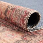 Rolled edge highlighting stitching and textured fabric of the rug