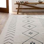 Angled view of Taos Tribal rug in entryway illuminated by window light behind wooden bench