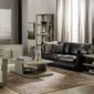 Wide living room scene with console, black leather sofa, armchairs, coffee table, bookshelves, and large windows