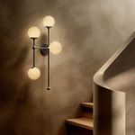 Armstrong 4 L Sconce lit on textured brown wall beside staircase with curved banister