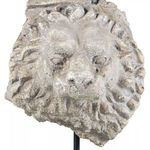 Close-up frontal view of textured lion head face with visible mane details on sculpture