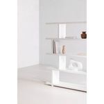 Close corner view of Miri Large Shelf in white with decorative vases, books, and abstract sculpture in a bright room corner