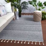 Rug styled in outdoor patio setting with wicker furniture, plants, and wood decking