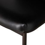 Close-up of front corner of seat showing stitching detail on black leather