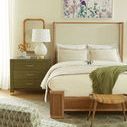 Front view of Atlas Bed in bedroom setting with bedside table and green throw blanket on bed