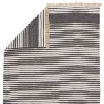 Rug flipped corner revealing striped pattern on reverse side