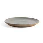 Single natural speckled clay dinner plate shown from a side angle highlighting flat profile and rim