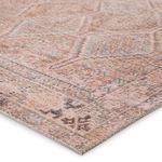 Side of Marquesa rug flipped up to reveal soft polyester backing and detailed edge stitching.