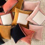 Overhead view of assorted velvet throw pillows in multiple colors and color block designs