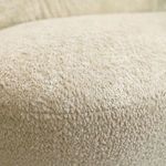 Close-up of cream upholstery texture showing soft, looped polyester fabric surface