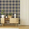 Plaid wallpaper in living room with light wood cabinet, plants, and white double doors