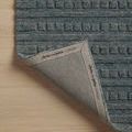 Corner folded back showing woven underside with Chris Loves Julia x Loloi branding label