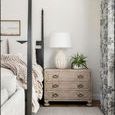 Bachelor's Chest in cozy bedroom corner next to four-poster bed, decorated with white lamp and green plant
