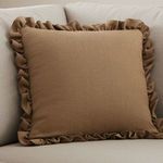 Betty Cushion styled on a light grey sofa showcasing its size and soft ruffle trim