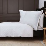 White Monaco coverlet with subtle diamond quilting and 1” flange, styled on a bed with matching pillow shams