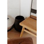Voss vessel placed on floor next to light wood chair with cane seat in a modern room